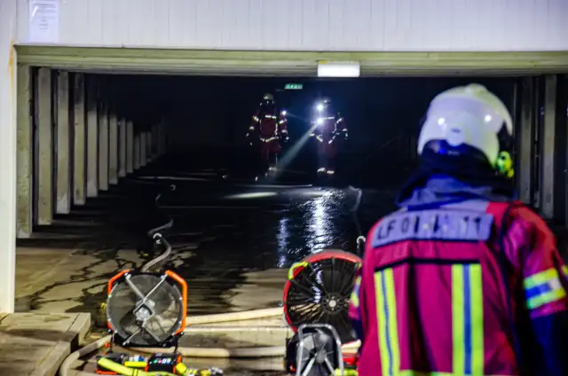Einsatzkräfte der Feuerwehr löschen einen Brand in einer Garage in Neuhof im Trockenen Kamp.