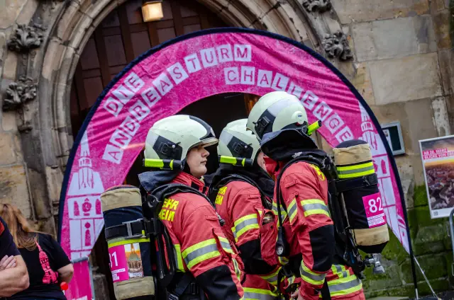 Teilnehmer der Blaulicht-Challenge warten in voller Ausrüstung vor dem Hildesheimer Andreasturm auf ihren Start. Bis zum Ziel mussten sie 364 Stufen überwinden.