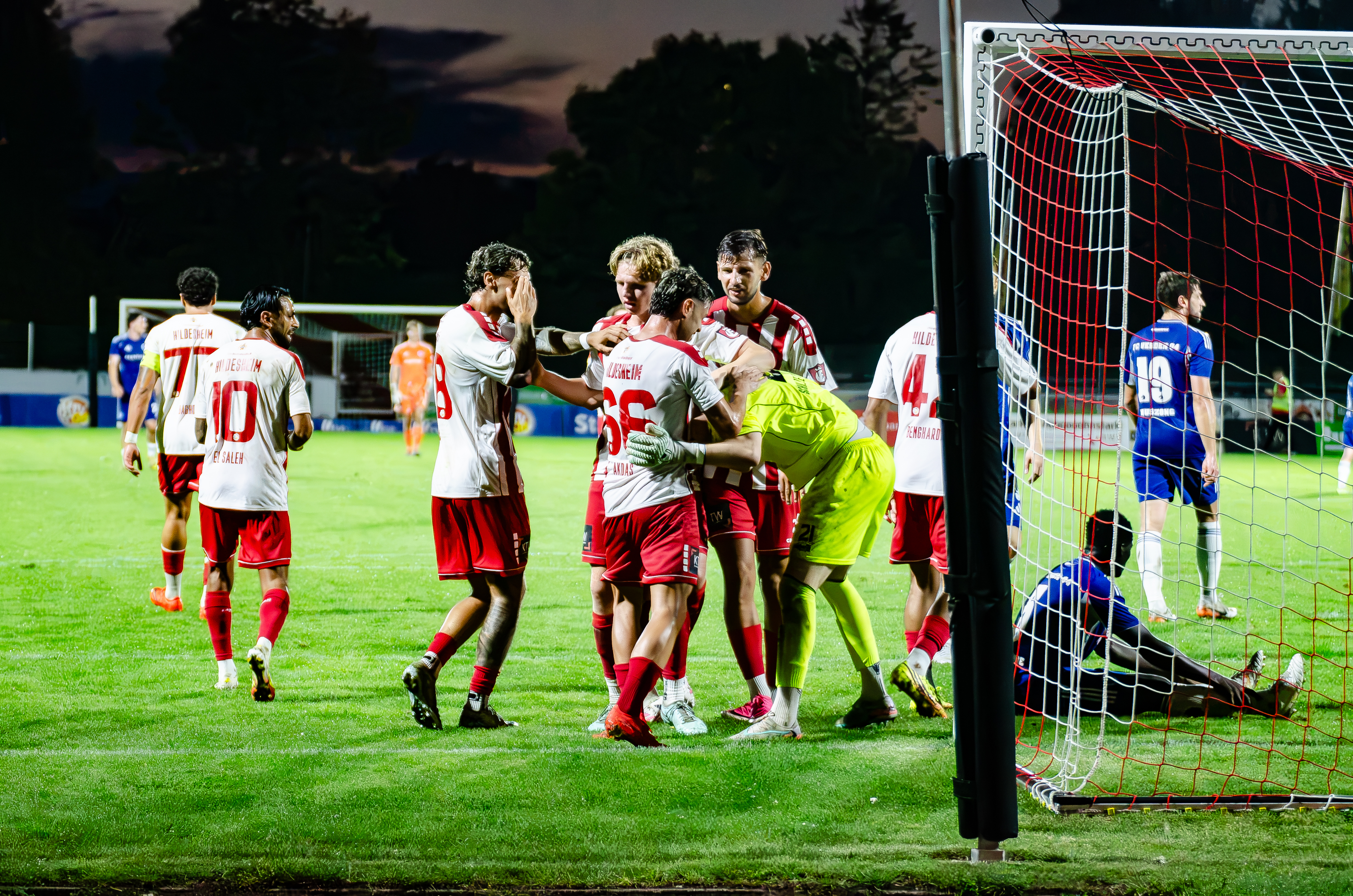 Die Spieler vom VfV jubeln mit Torwart Lennart Kökelsum nach einem gehaltenen Elfer.